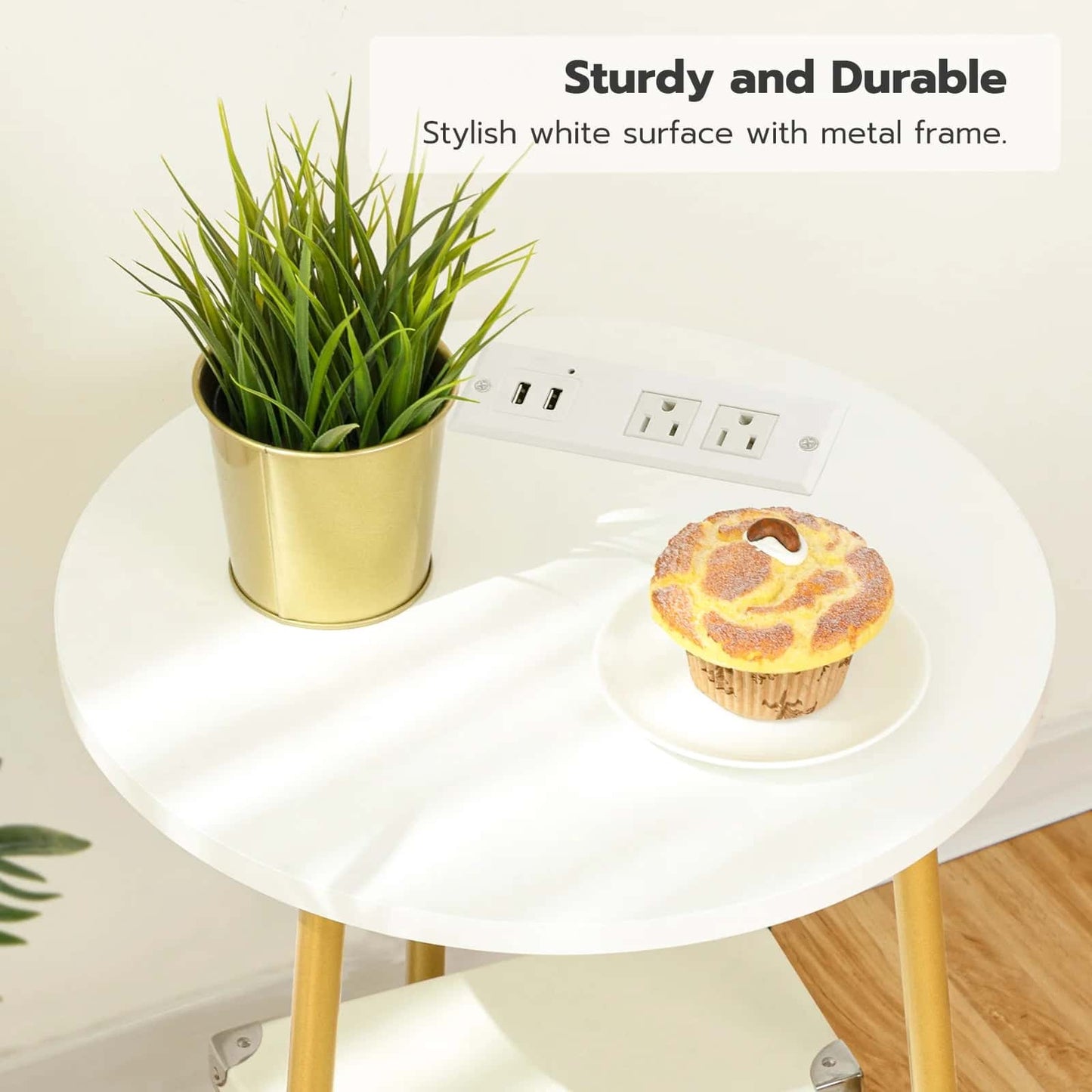 Round white table with gold legs, plant, and cupcake on a light background