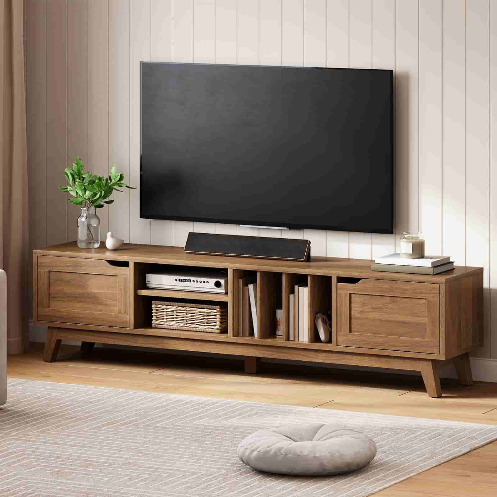 Wooden TV stand with a television and decorative items in a living room.