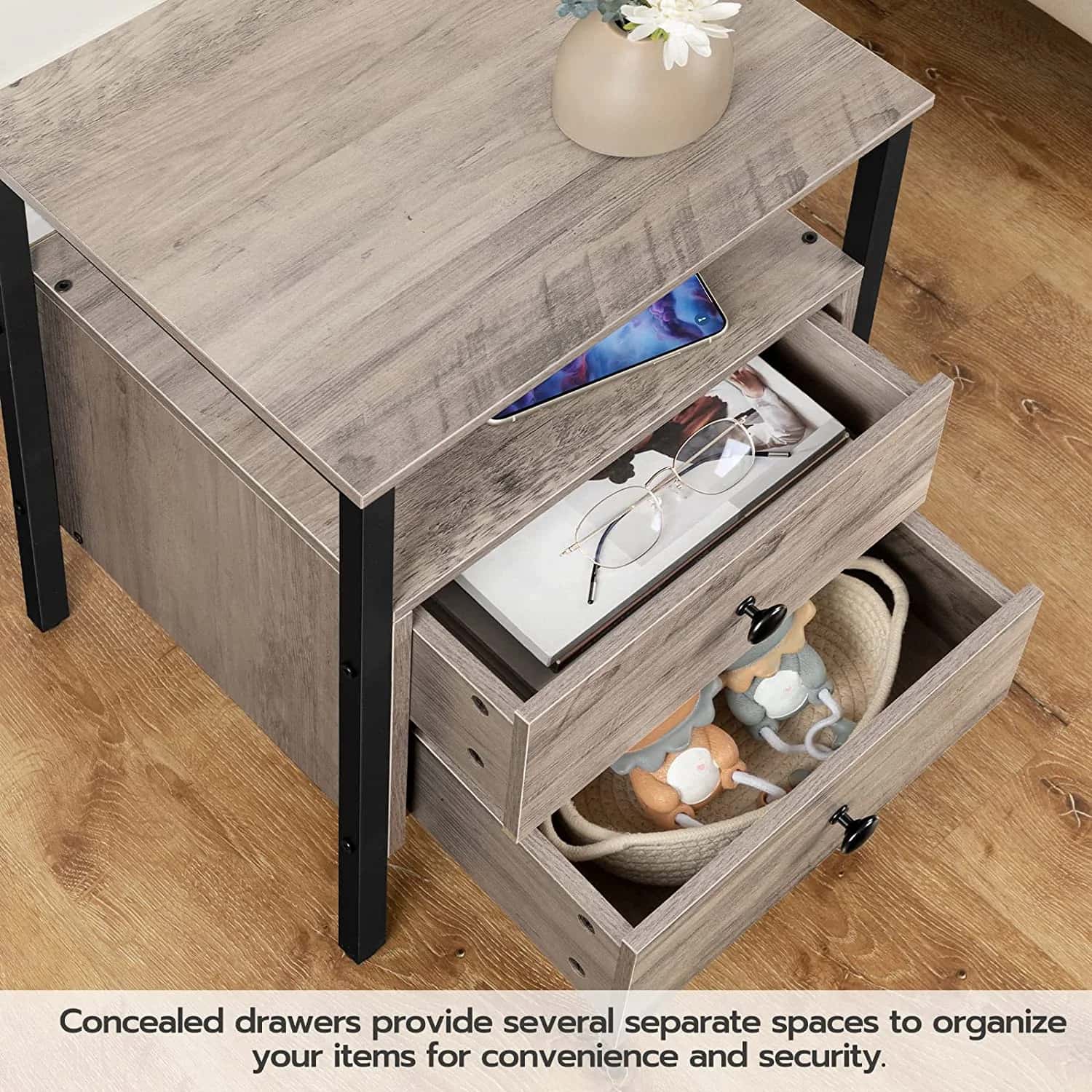 Wooden side table with open drawers containing items on a wooden floor.