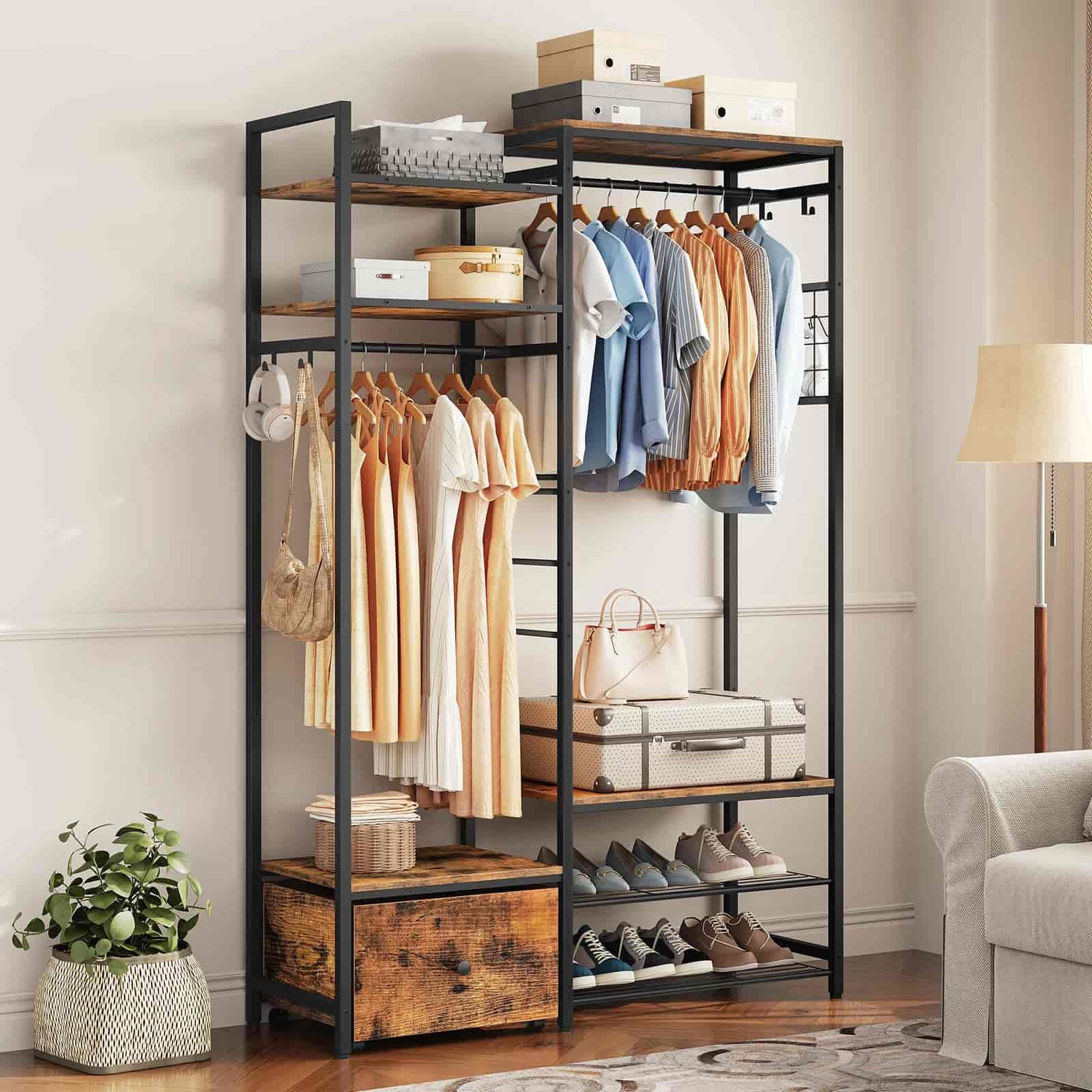 Clothing rack with clothes, shoes, and bags in a room setting.
