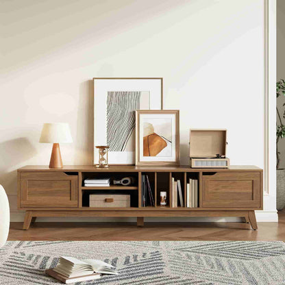 Wooden entertainment console with books, decor items, and framed pictures in a living room setting.