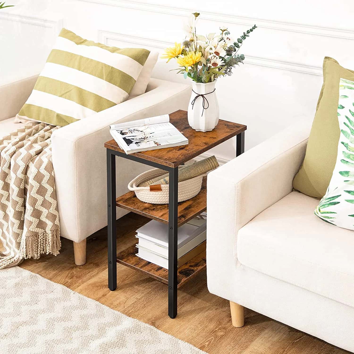 Small wooden side table with books and a vase in a living room setting.