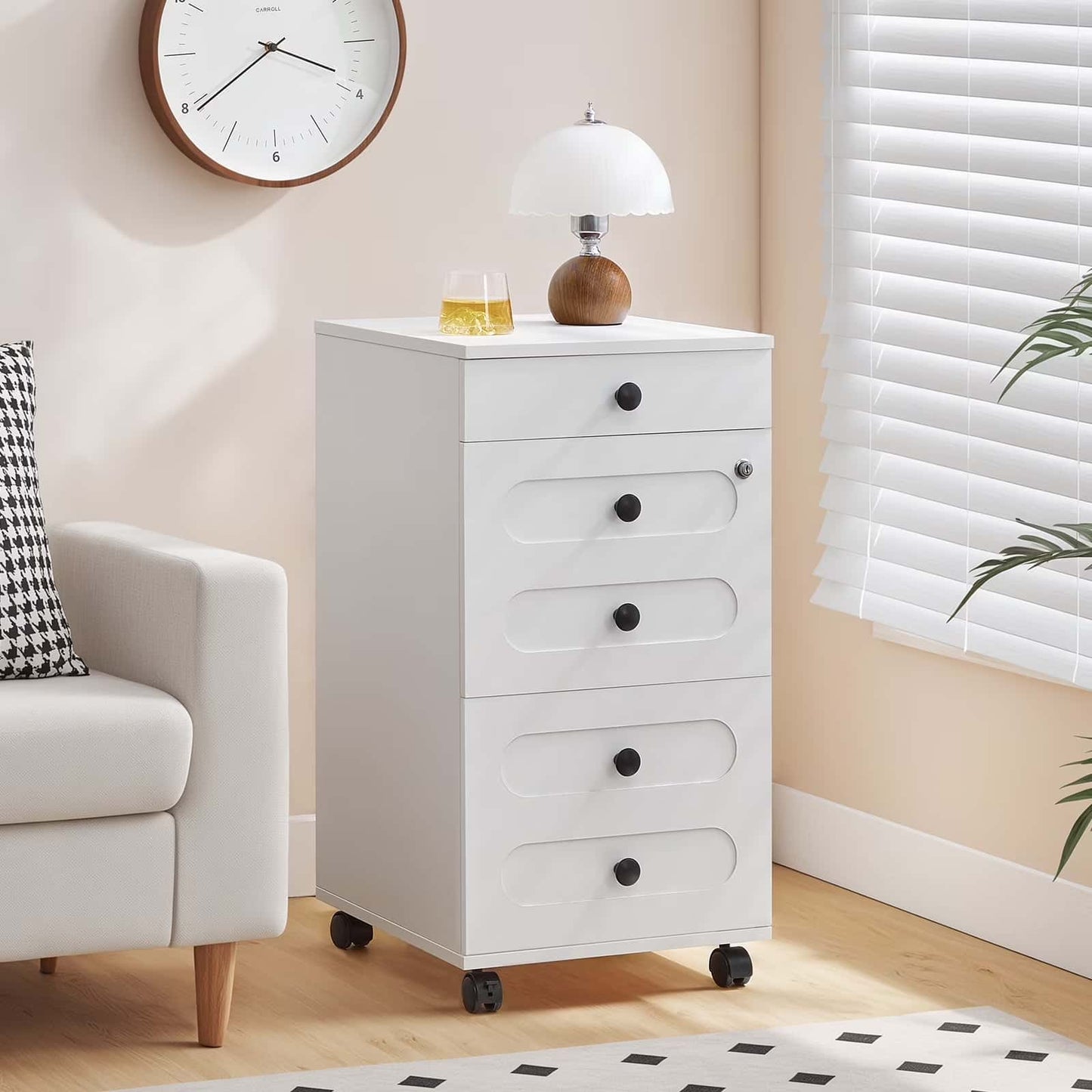 White dresser with drawers in a room with a clock, lamp, and plant.