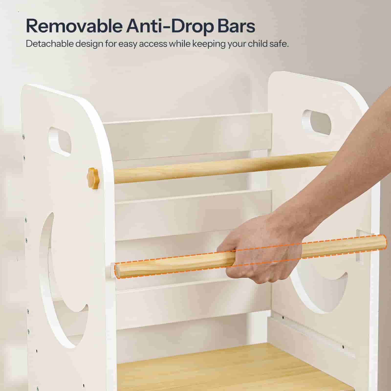 White crib with removable anti-drop bars and a hand demonstrating their use.