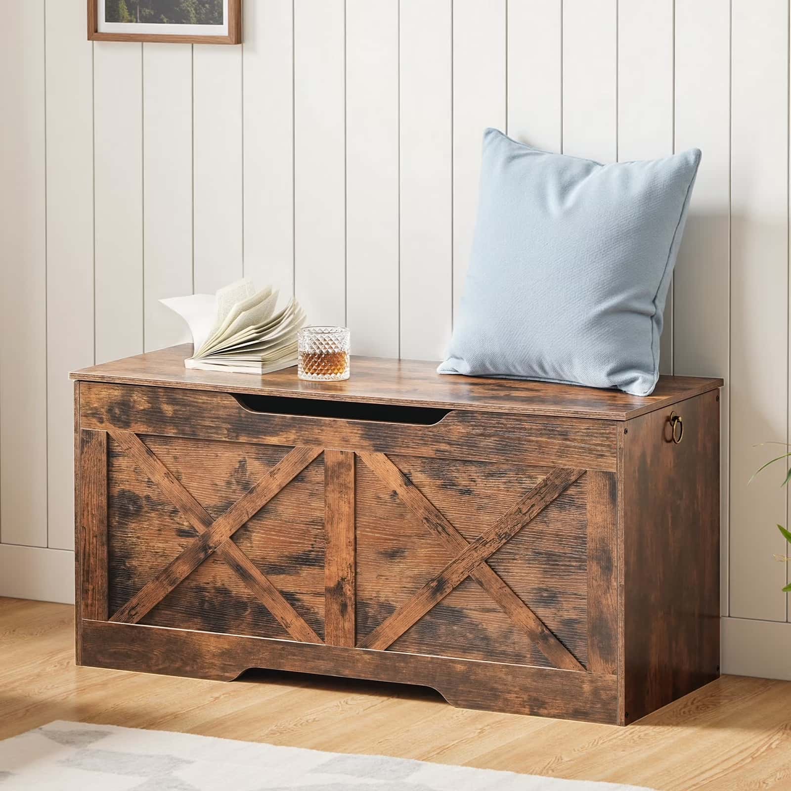 Wooden storage bench with a glass of whiskey and folded towels on a wooden floor.