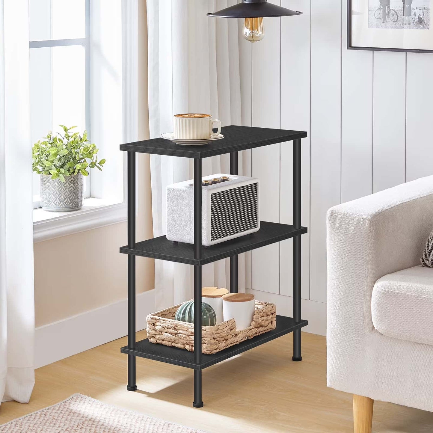 Black three-tier shelf in a living room with decor items on it.
