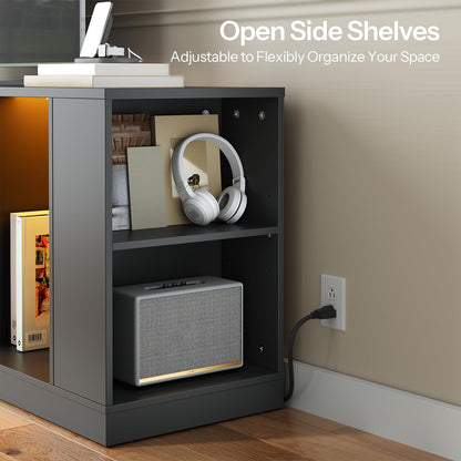 Black side shelf with open shelves, headphones, and a speaker, against a neutral wall.