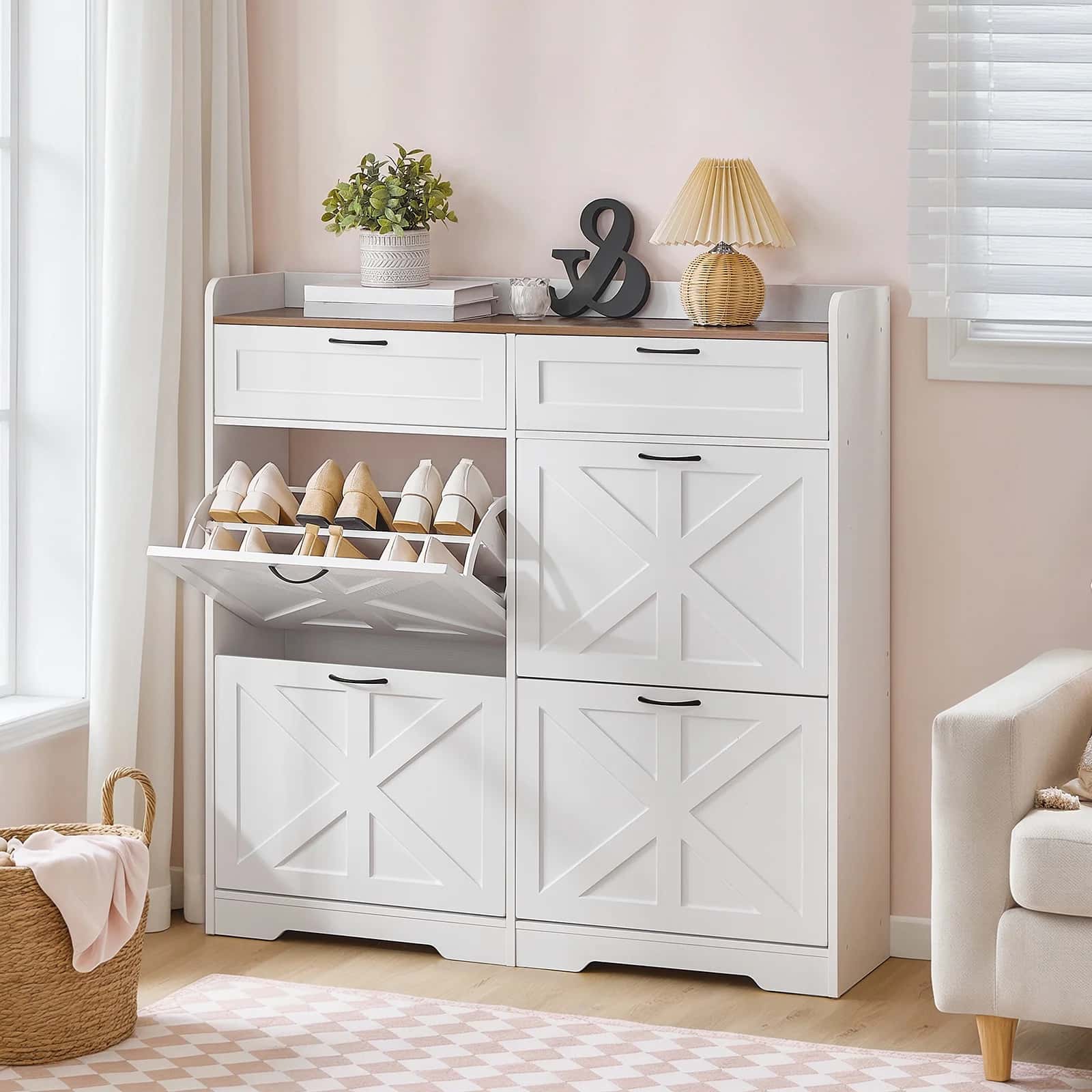 White shoe cabinet with open door displaying shoes, placed in a room with a couch and window.