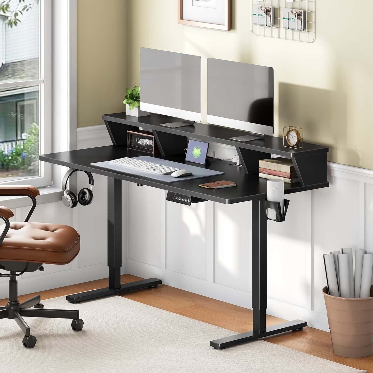 Black computer desk with two monitors, chair, and office items in a room.