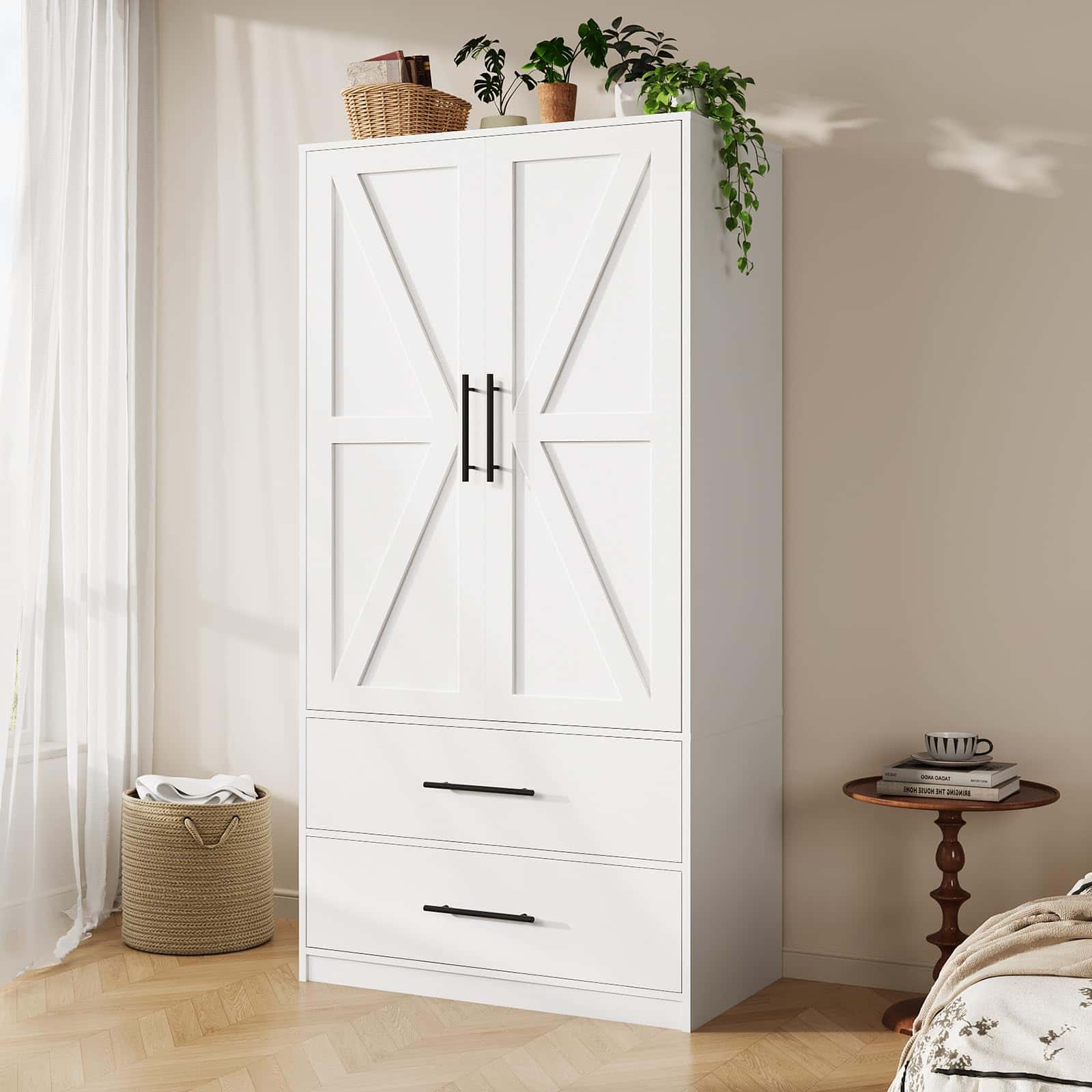 White wardrobe with black handles in a room with a side table and basket.
