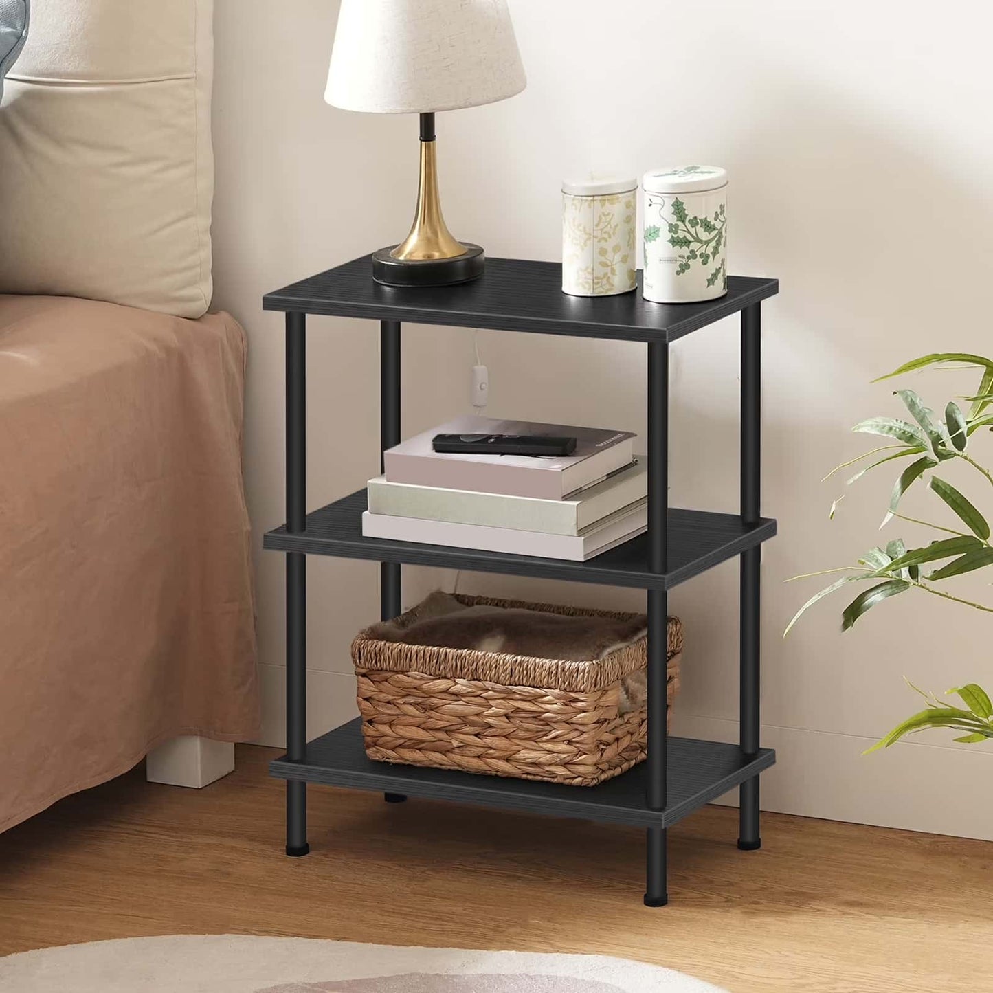 Black three-tier nightstand with books, a basket, and decorative items in a bedroom setting.