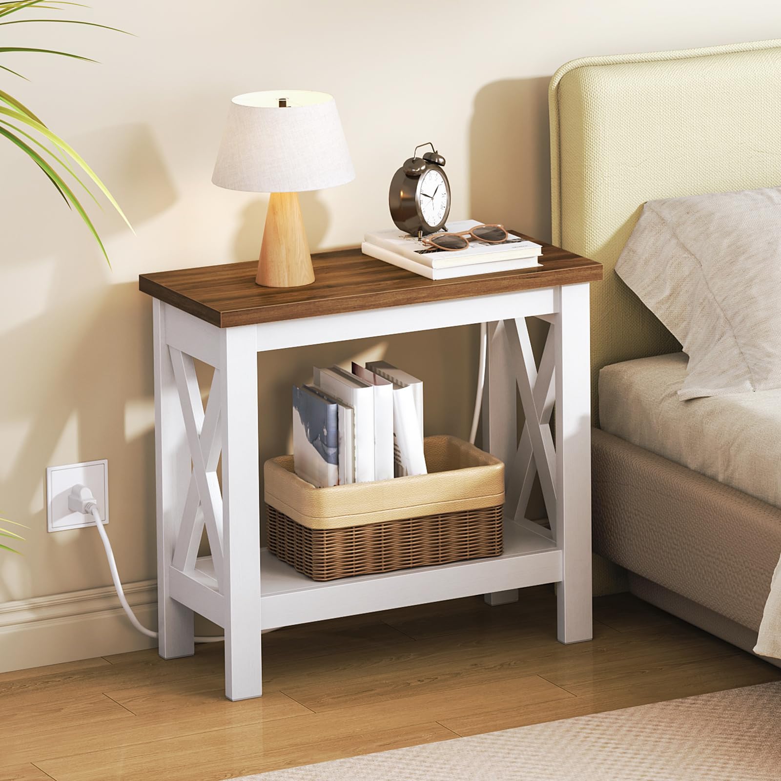 Wooden nightstand with lamp, books, and clock next to a bed