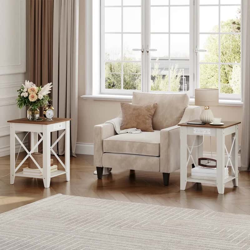 Living room with beige armchair and two white side tables with wooden tops.