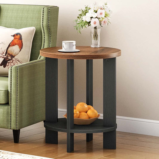 Small round wooden side table with black legs next to a green armchair with a bird pillow.