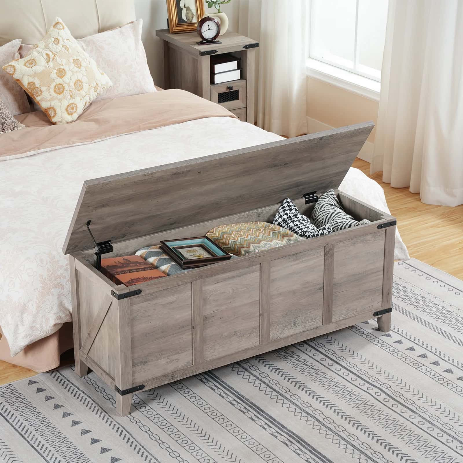 Wooden storage bench in a bedroom with items inside, next to a bed.