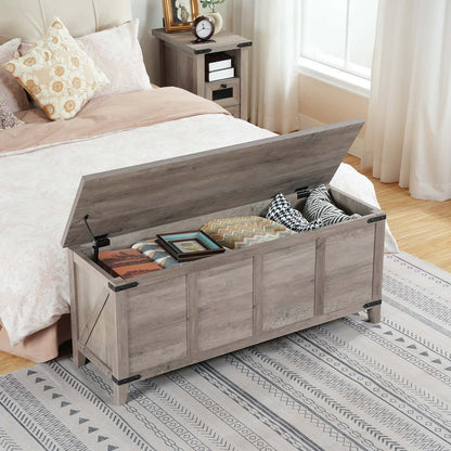 Wooden storage bench in a bedroom with items inside, next to a bed.