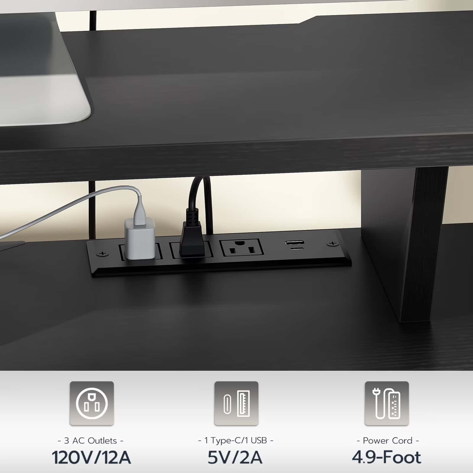 Black desk with power outlet panel underneath, showing electrical outlets and USB ports.
