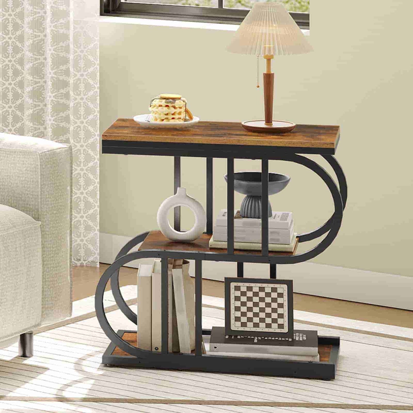 Three-tiered side table with books, a vase, and a chessboard in a living room setting.