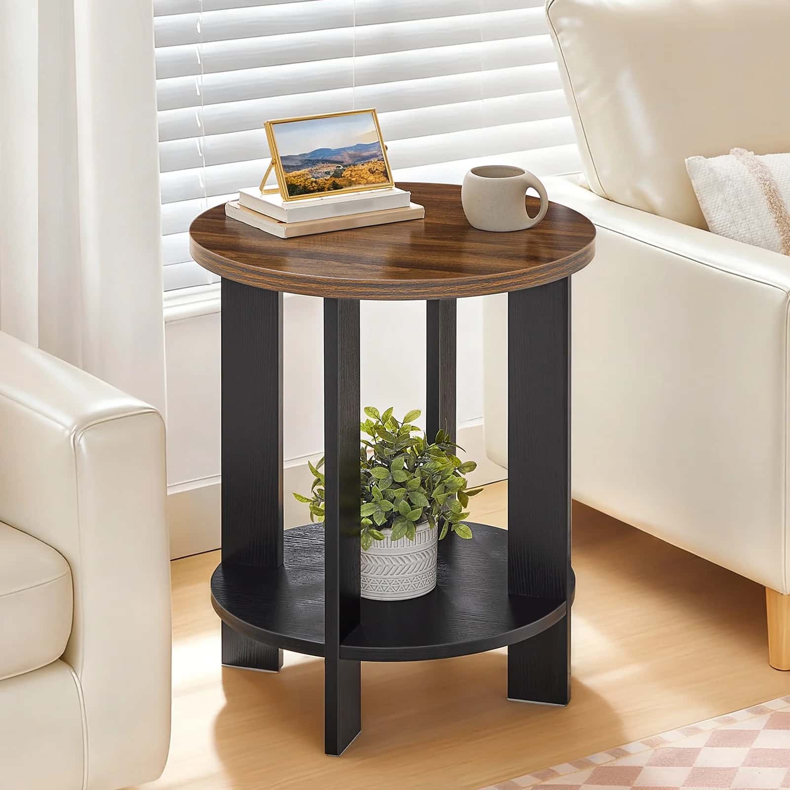 Round wooden side table with black legs in a living room setting.
