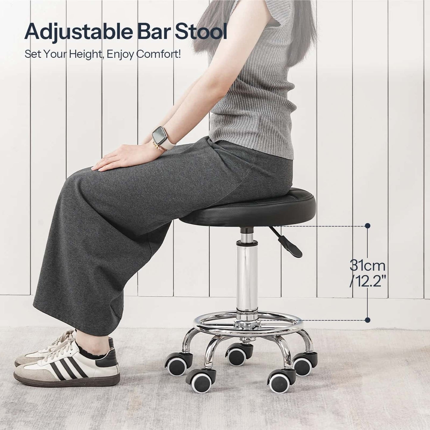 Person sitting on an adjustable bar stool with a white wooden floor background