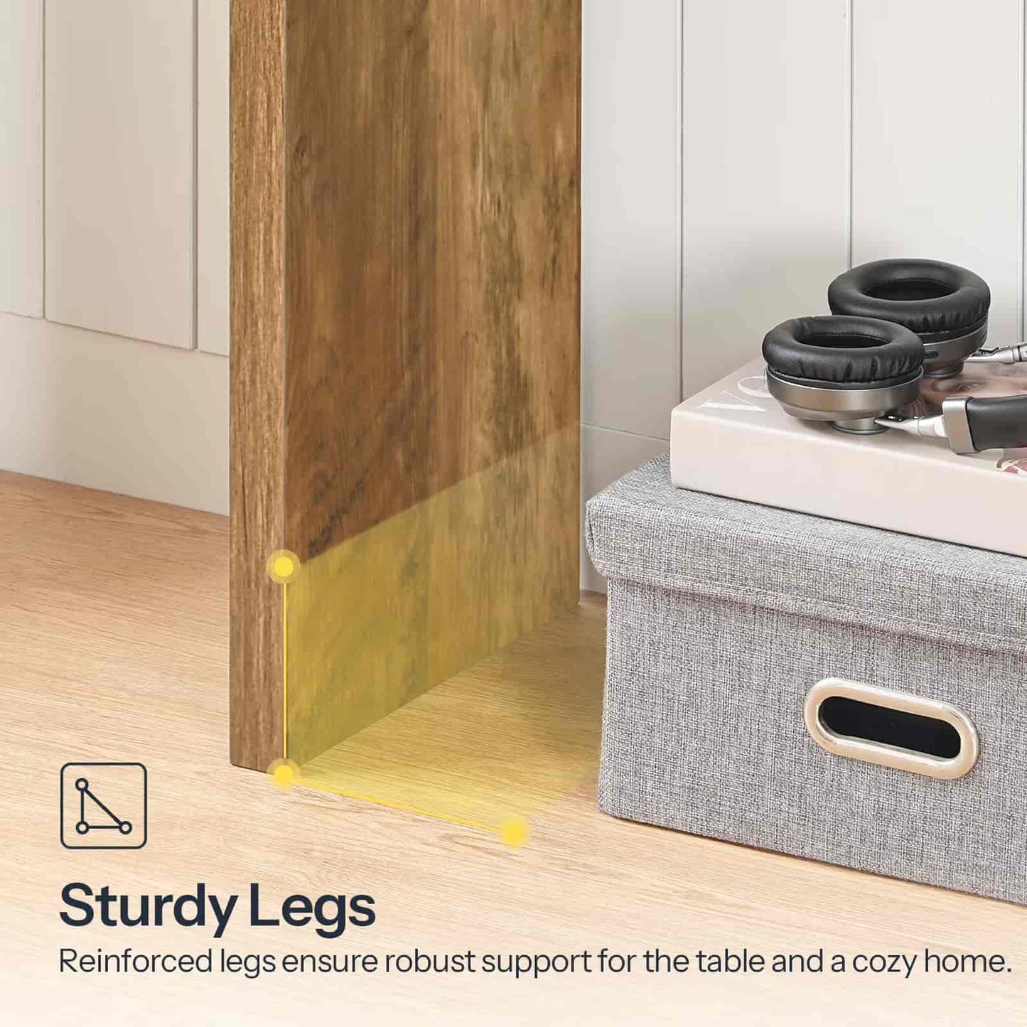 Gray storage ottoman with headphones on top next to a wooden cabinet, emphasizing sturdy legs.