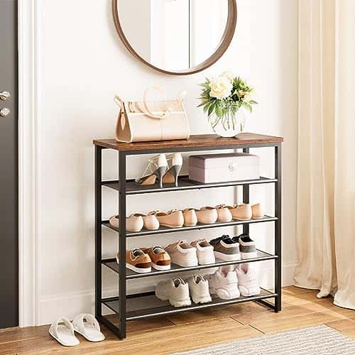 Shoe rack with shoes on a wooden floor in a room with a mirror and curtains.