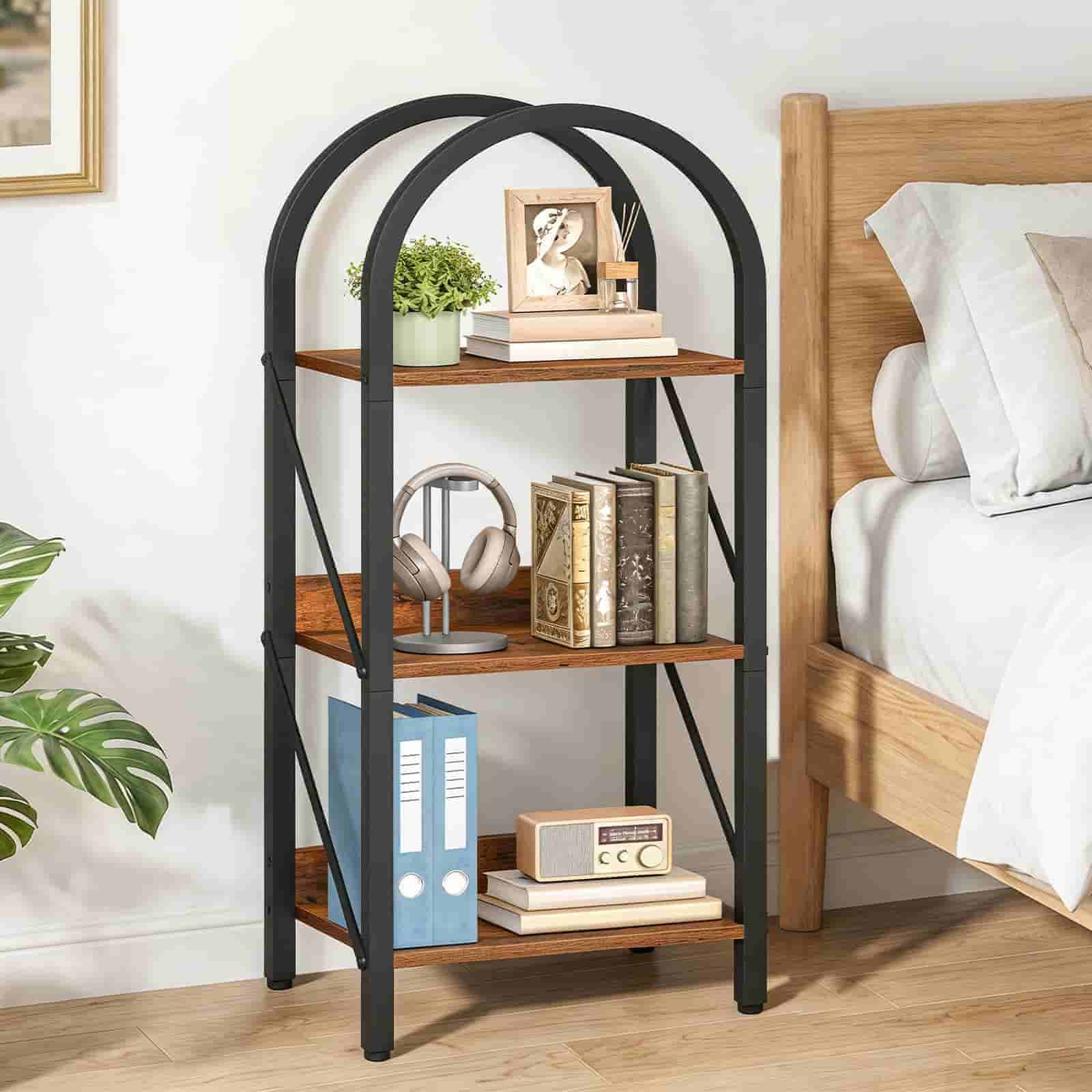 Three-tiered metal shelf with wooden shelves against a bedroom wall.