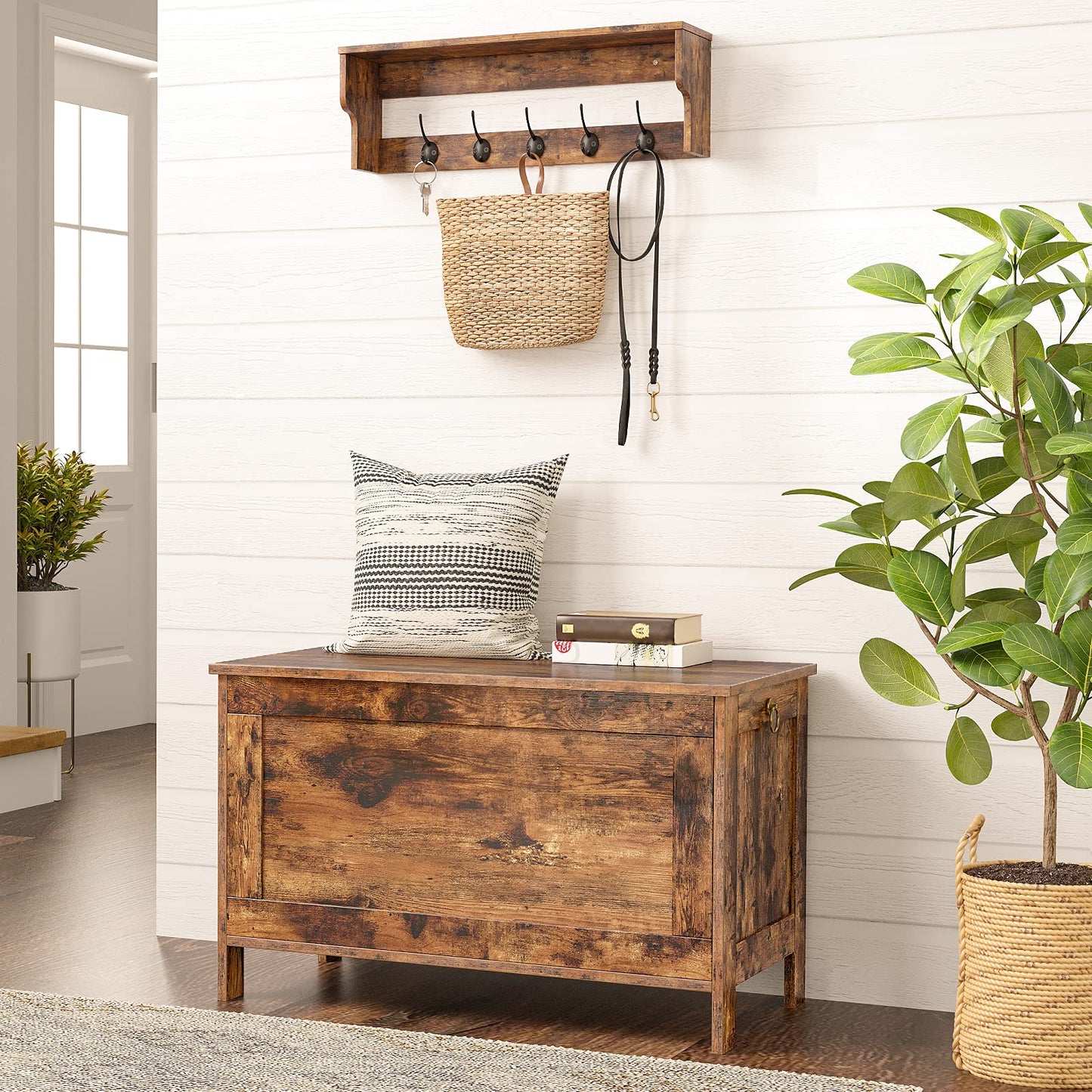 Wooden coat rack with hooks above a wooden bench in a room with plants and a pillow.
