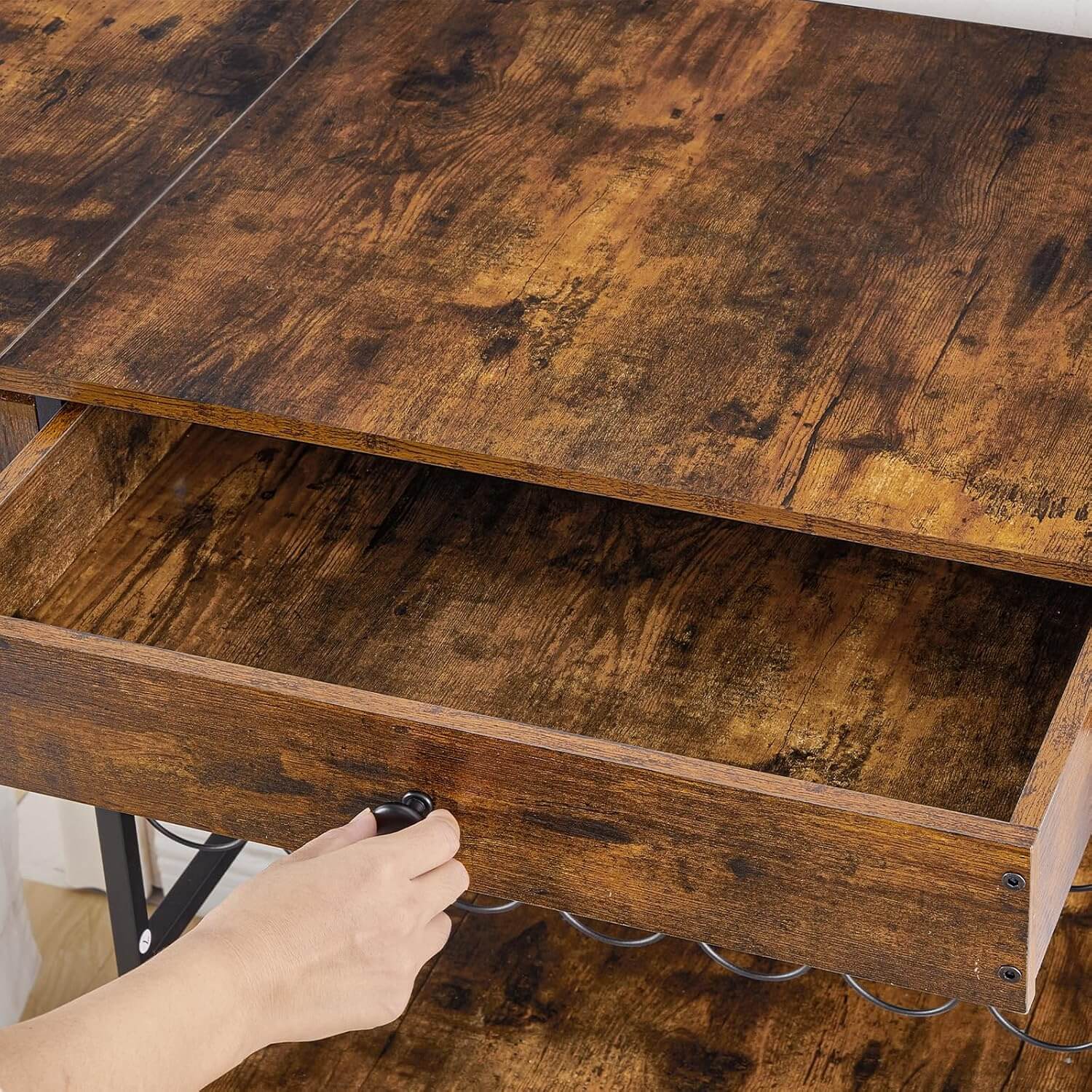 Wooden desk with a hand opening a drawer