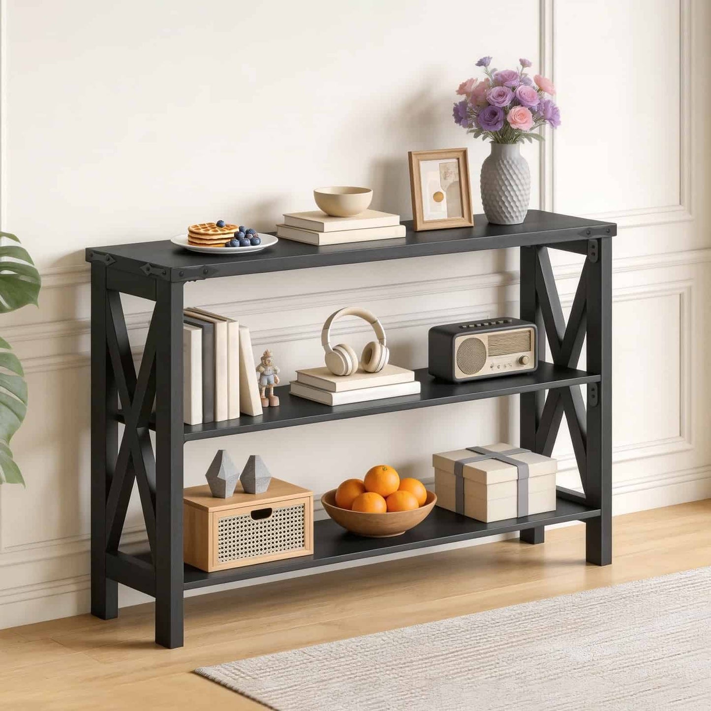 Black wood skinny hallway table styled beautifully with books and decor, standing against a cream-colored living room wall.
