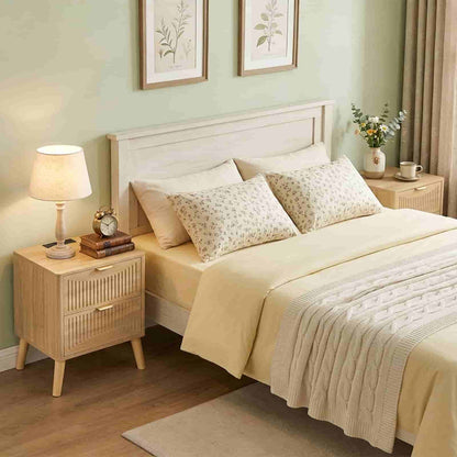 Wide-angle view of a bright Scandinavian bedroom showcasing the matching wood bedframe and bedside table.