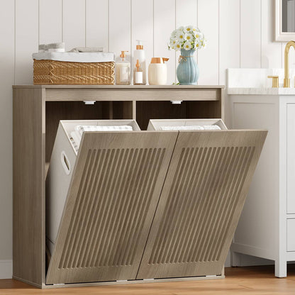 Greige double tilt-out laundry hamper cabinet styled in a modern bathroom holding baskets and towels.