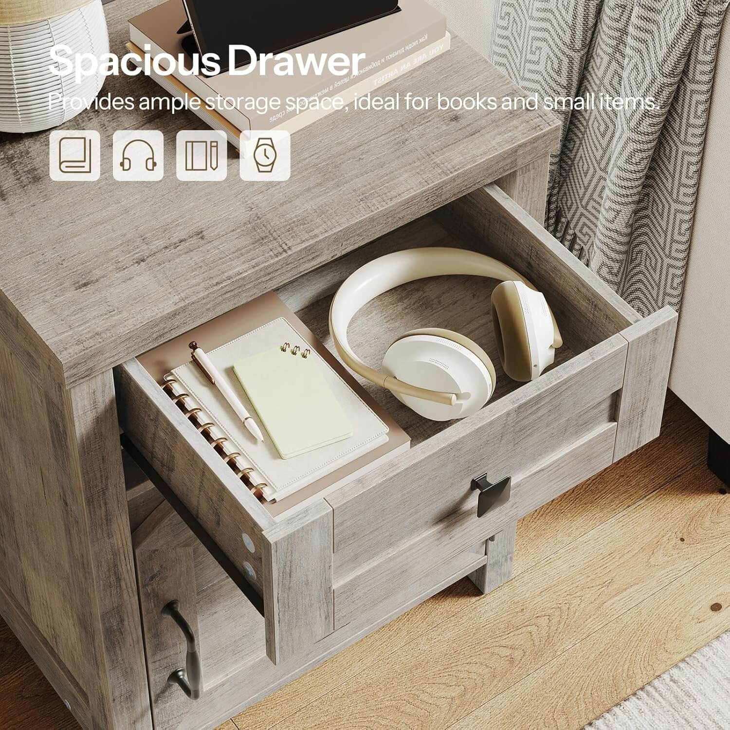 Wooden drawer with books, headphones, and a notebook on a wooden floor.