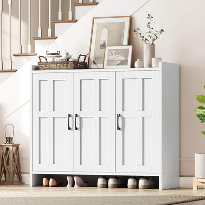 White storage cabinet with shoes underneath, placed in a room with a staircase and decorative items.
