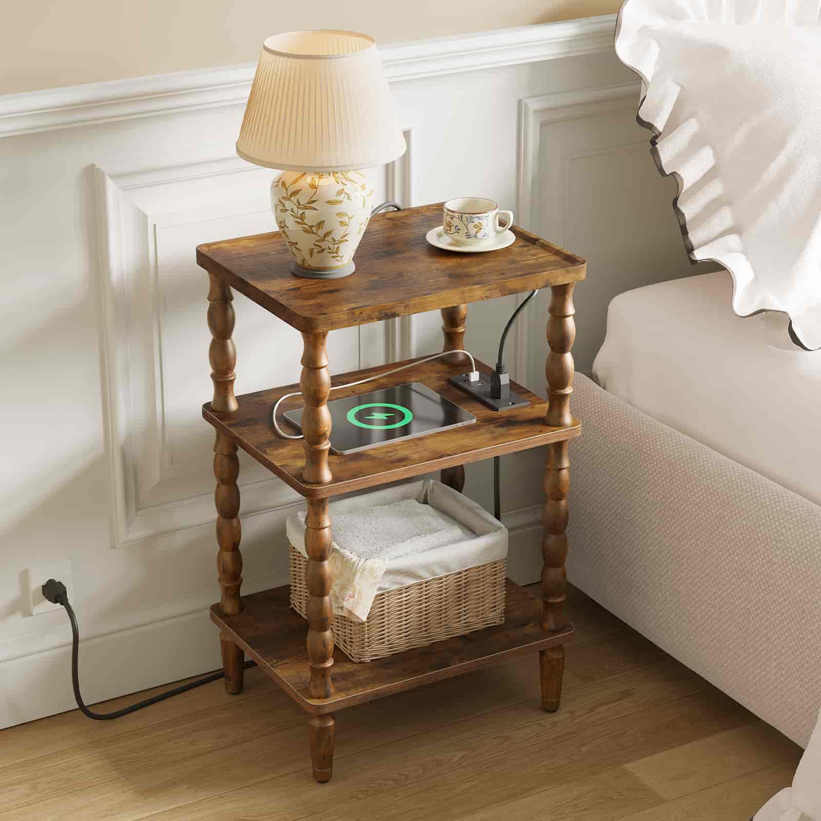 Farmhouse style rustic wood nightstand with a glowing table lamp placed next to a bed in a cozy bedroom.