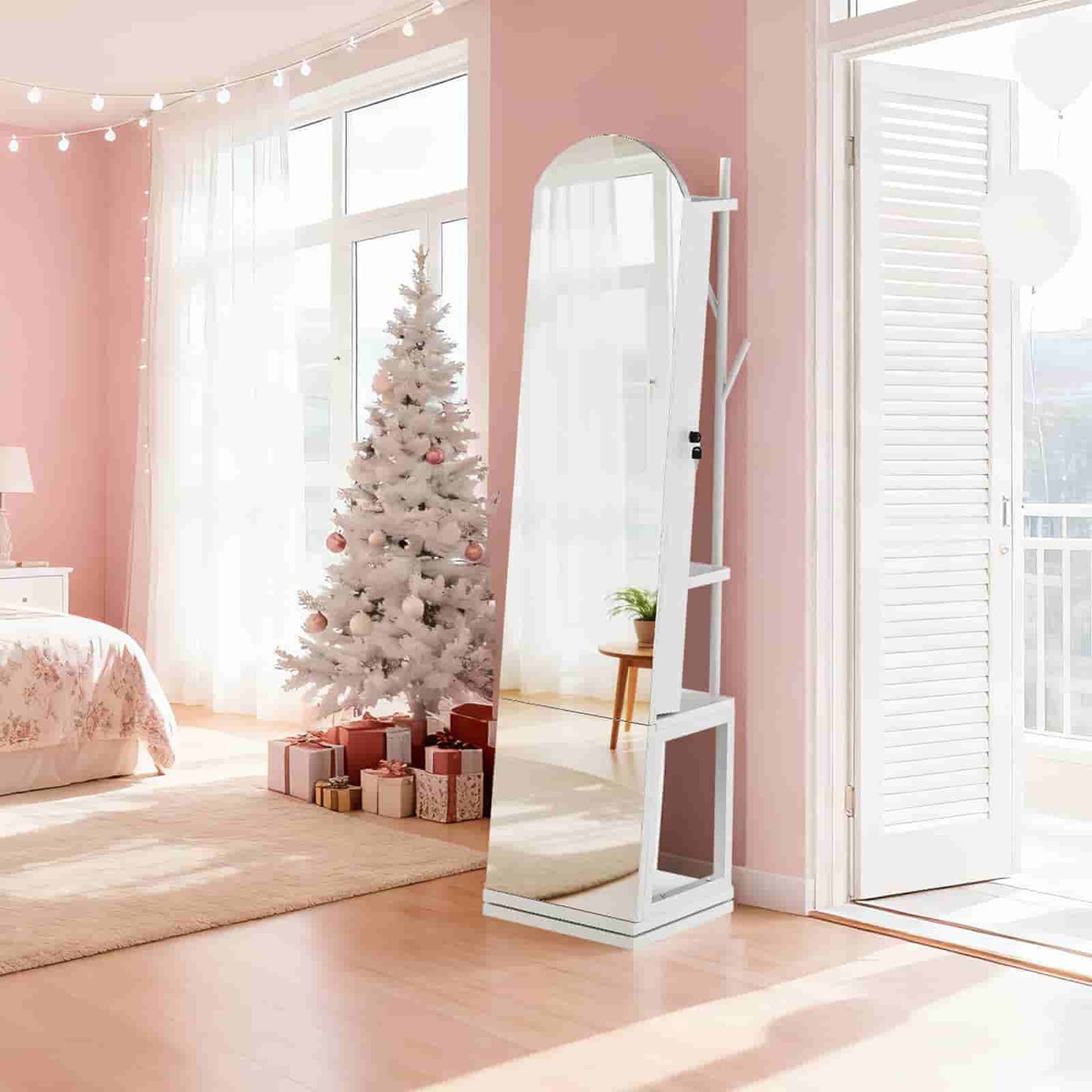 Freestanding white jewelry mirror armoire placed in a bright, modern pink-walled bedroom.