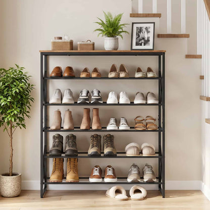 Freestanding rustic brown shoe shelf standing against a white wall next to an indoor plant.