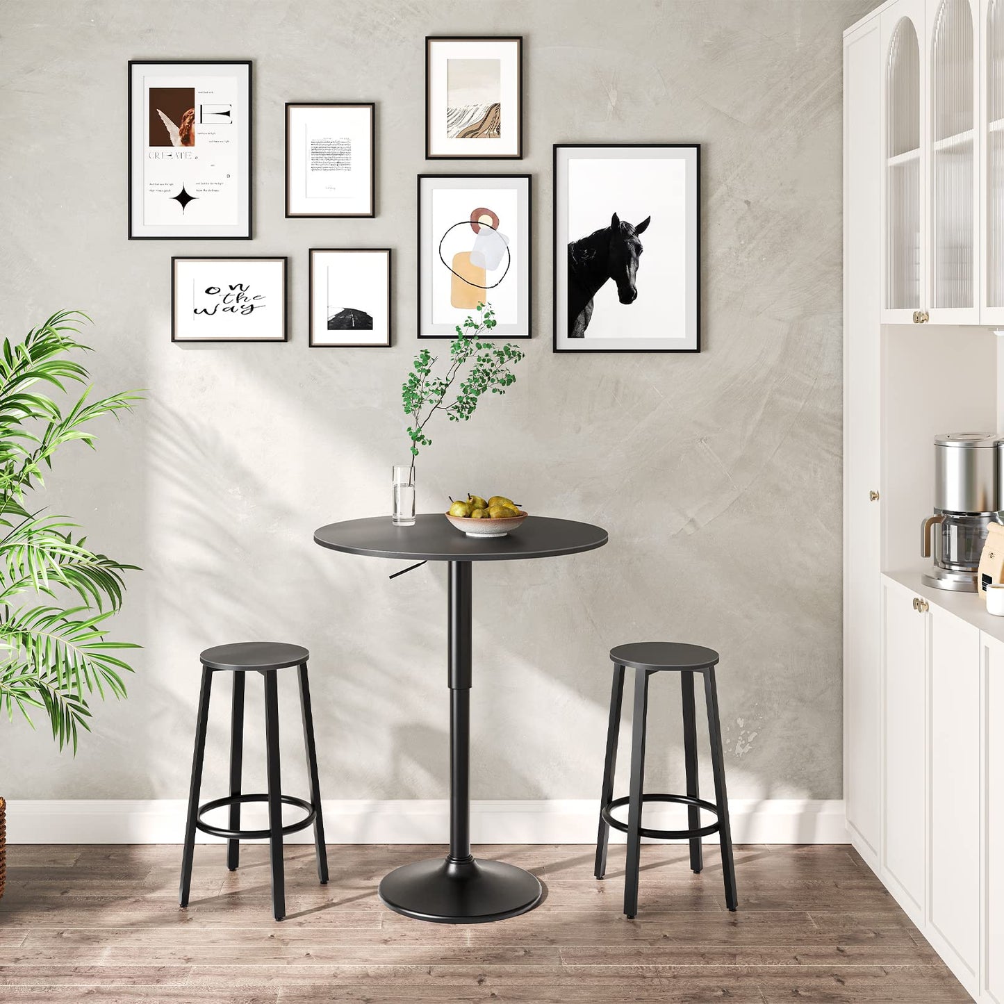 HOOBRO all black adjustable height round bar table paired with two matching black bar stools against a white wall.