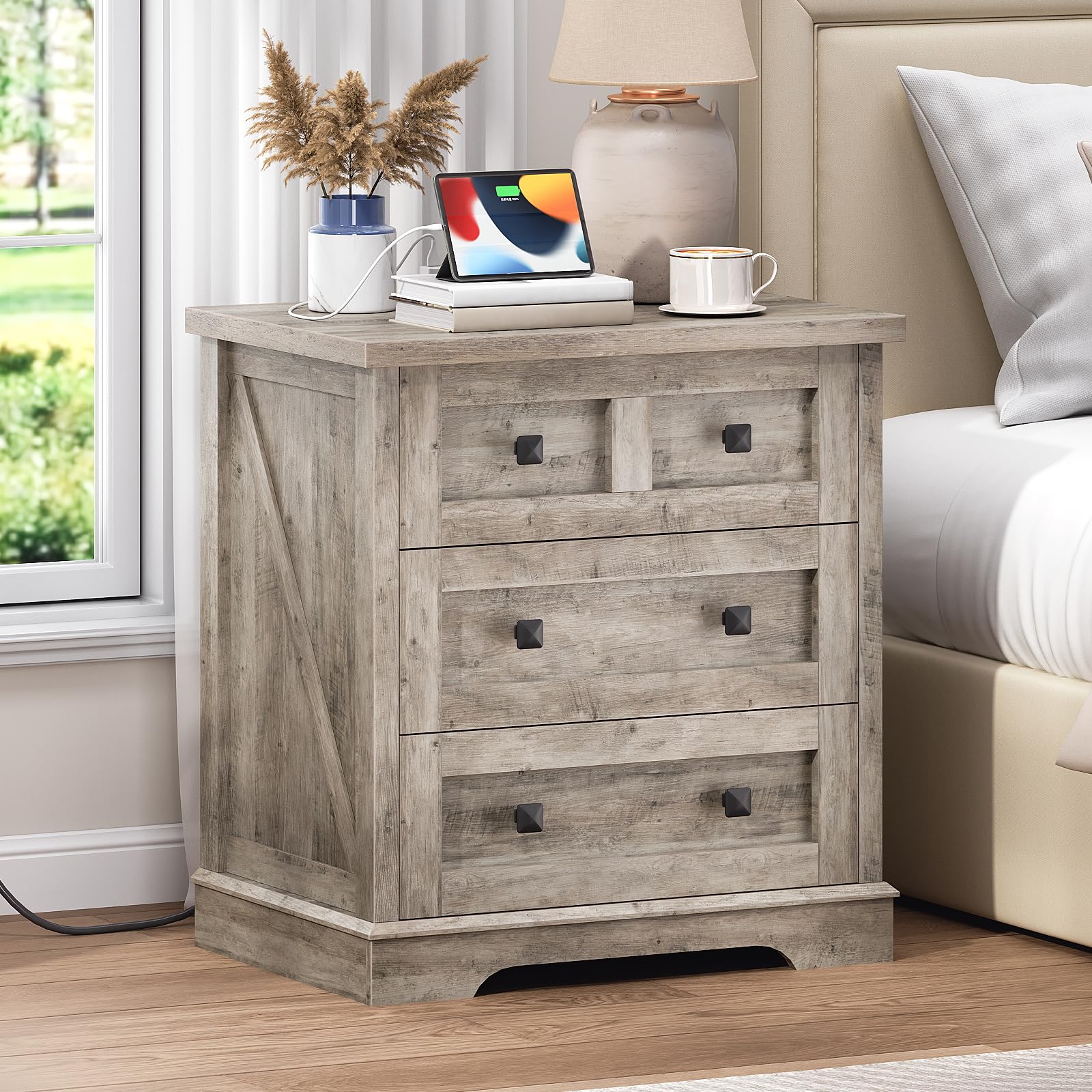 HOOBRO farmhouse greige nightstand with a hidden charging station standing next to a bed holding a tablet.