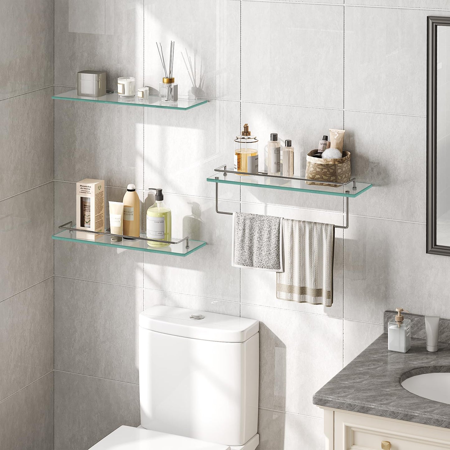 Bathroom with glass shelves, toiletries, and towels on a tiled wall.