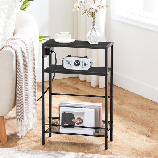 HOOBRO skinny black end table with a side charging station standing next to a cream couch holding an alarm clock.