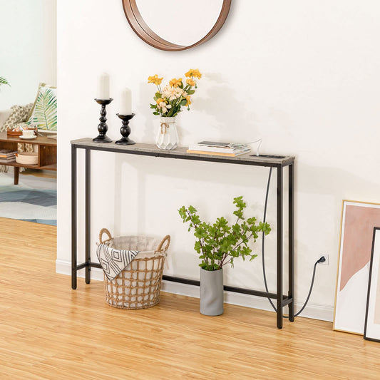 Console table in a living room with decor items including candles, flowers, and a plant.