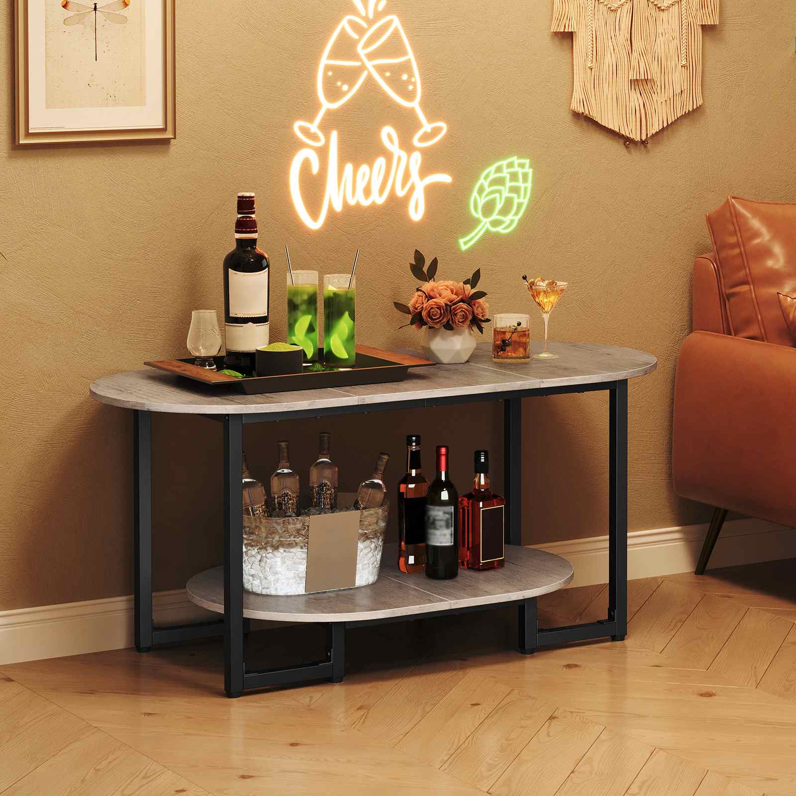 Industrial oval table styled as a mini home bar holding wine bottles, glasses, and snacks under a neon sign.