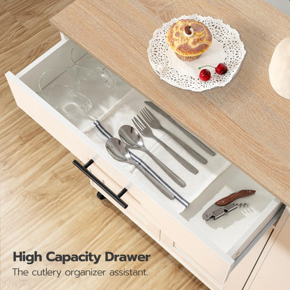 Open kitchen drawer with cutlery and a cupcake on a wooden surface