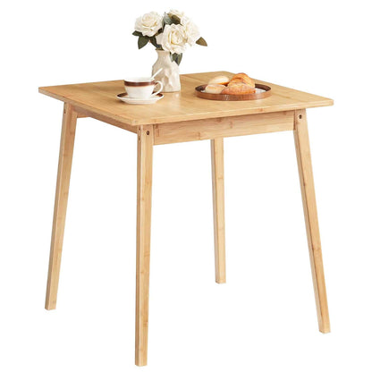 Studio shot of a minimalist natural bamboo dining table with tapered legs on a clean background.