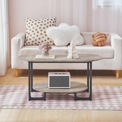 Minimalist oval center table placed in front of a white sofa holding a retro speaker and decor.