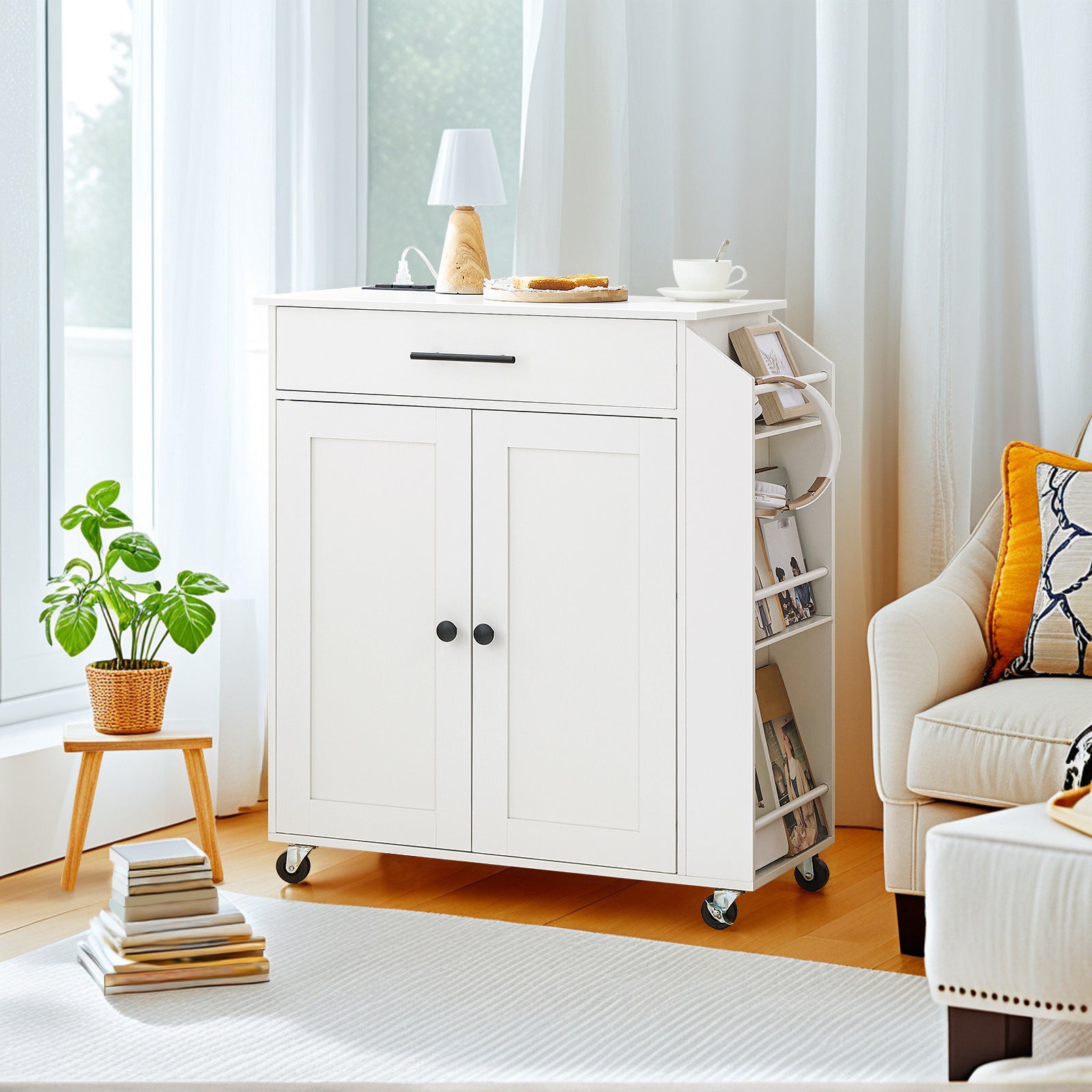 White kitchen cart with storage compartments in a bright room with a chair and plant.