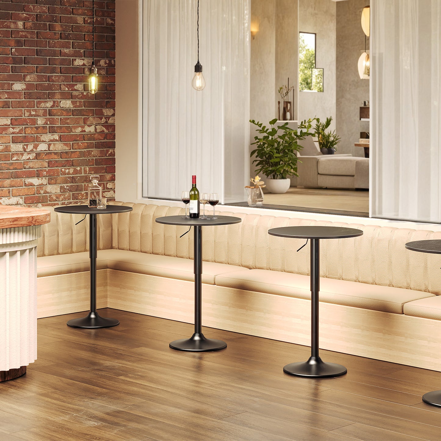 Three pieces of modern black bistro bar tables arranged in a row in a restaurant lounge next to a bench
