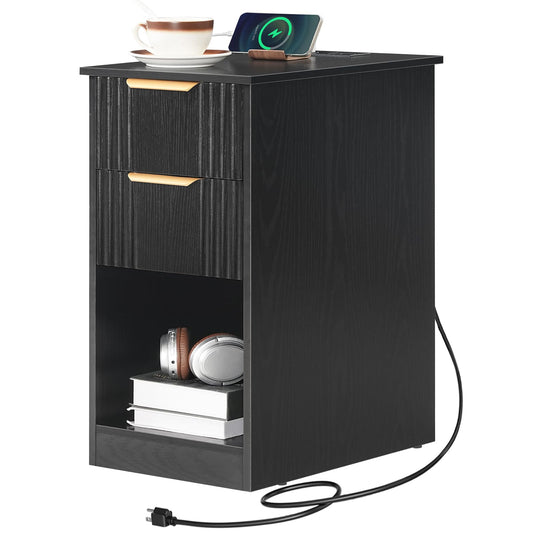 Black nightstand with two drawers and a small shelf, featuring a phone, cup, and books on top.