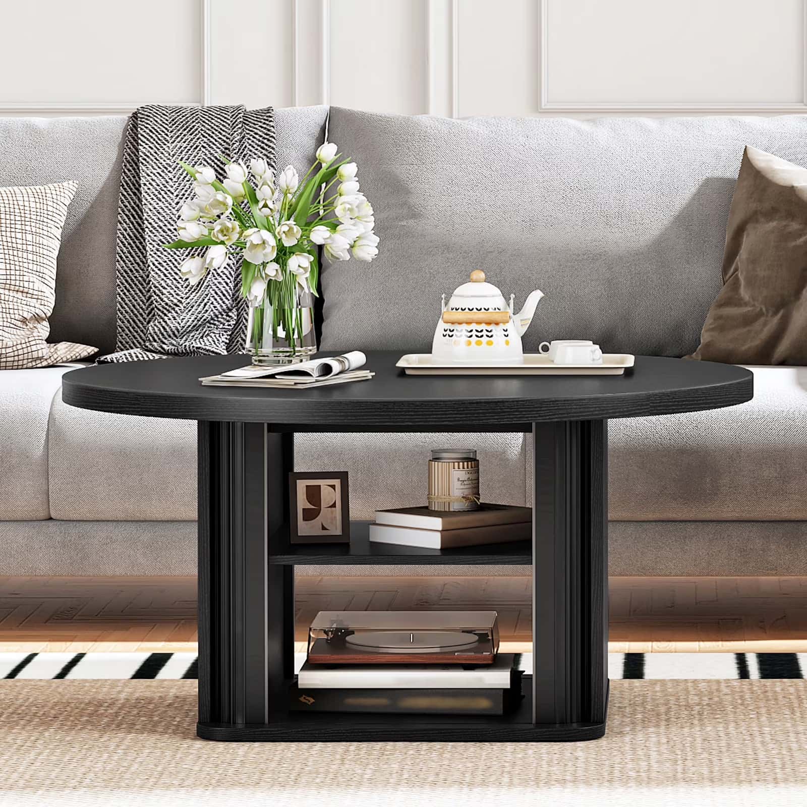 Modern 31.5 inch black round coffee table with open shelves styled in a contemporary living room.